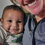 Christian is registered to the contest to win money with this photo: baby, child, woman, smile, happy, indoor, portrait, person, clothing, face, drool, nose_piercing, zipper, casual_wear, affection, close_up, family, skin, head, eyes