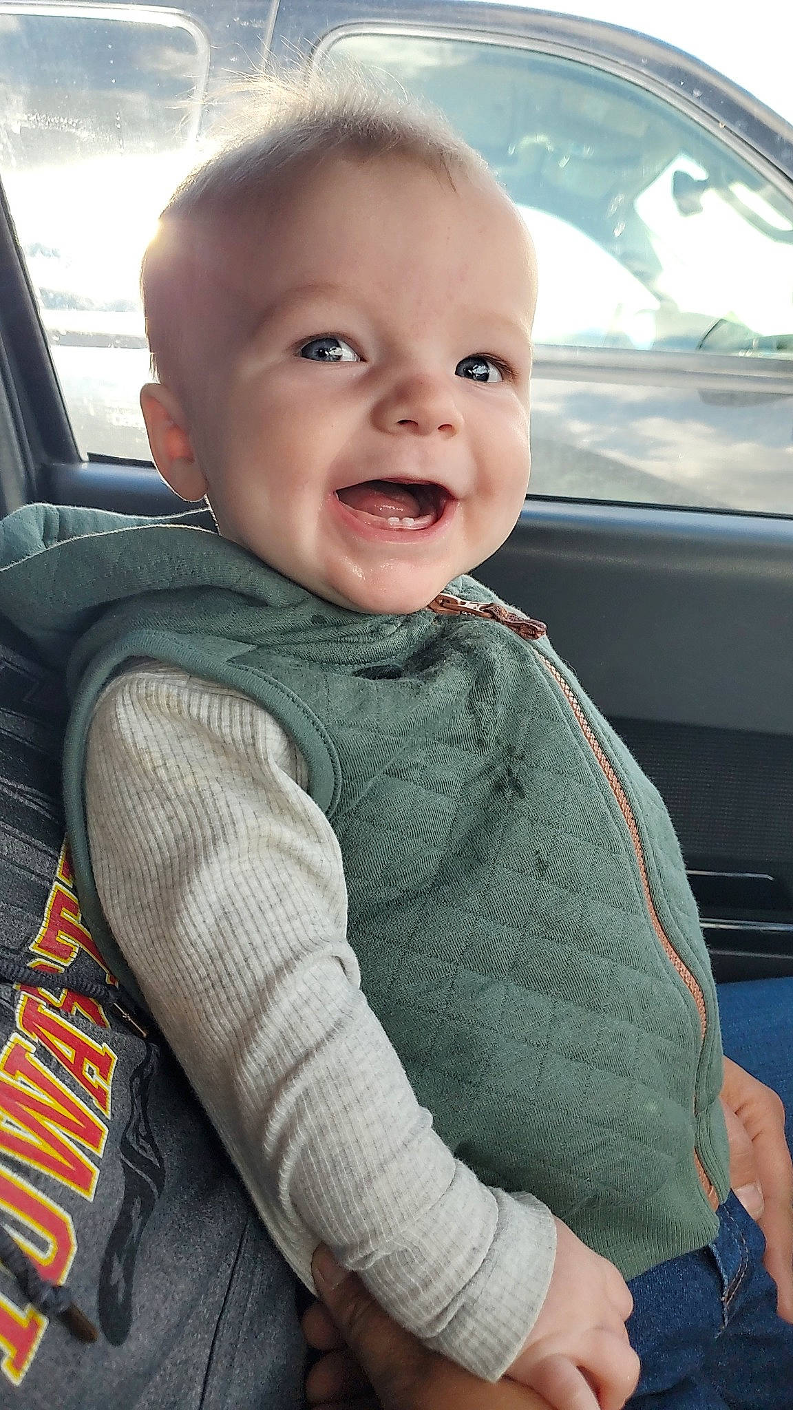 William is registered to the contest to win money with this photo: automotive_exterior, baby_toddler_clothing, car_seat, cheek, comfort, cool, face, finger, gesture, hand, happy, motor_vehicle, nose, person, seat_belt, skin, sleeve, smile, toddler, vehicle_door
