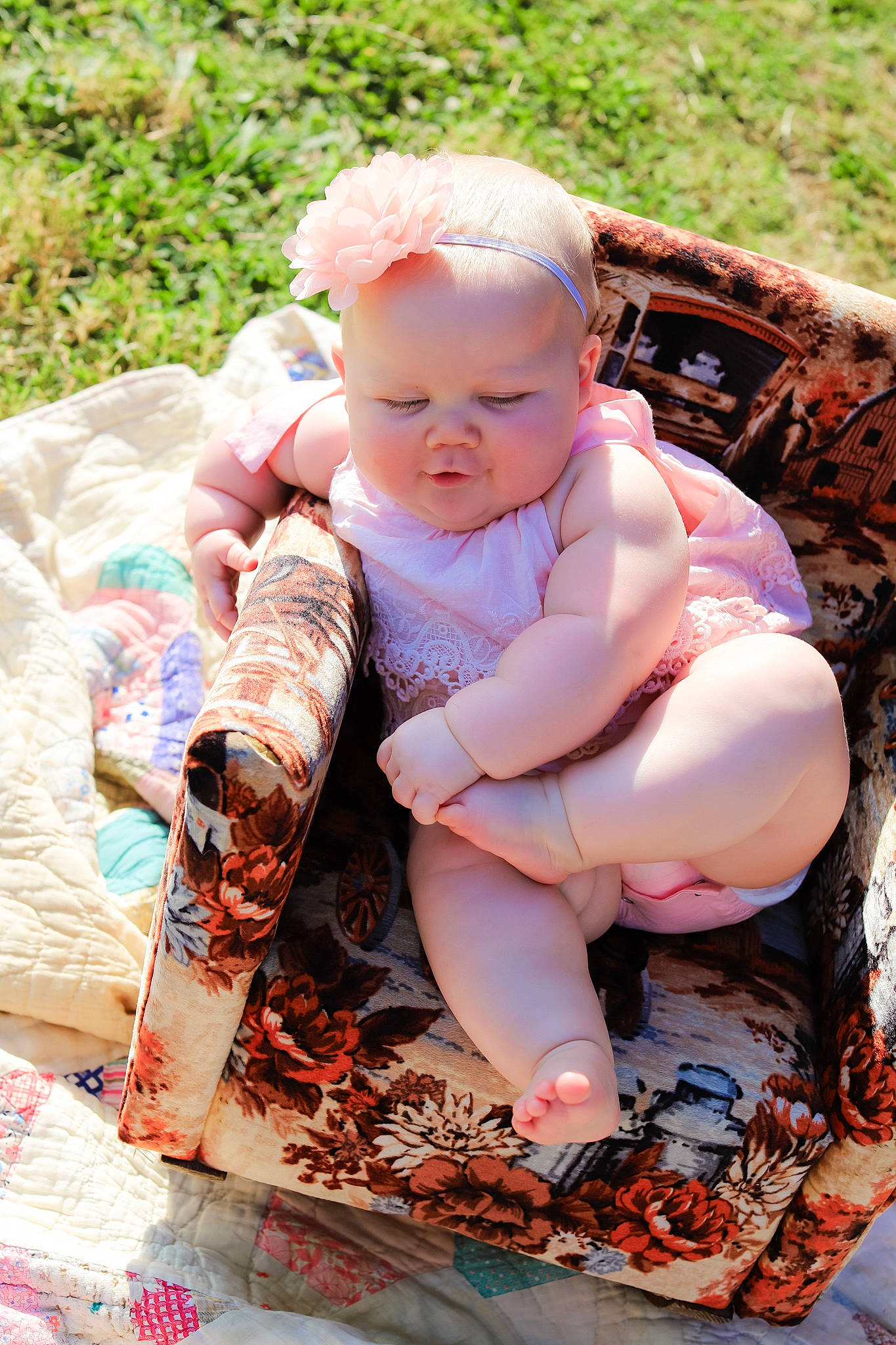 Memphis is registered to the contest to win money with this photo: baby, baby_toddler_clothing, child, fawn, finger, foot, grass, happy, hat, human_body, leg, pattern, people_in_nature, person, pink, plant, sitting, skin, textile, toddler
