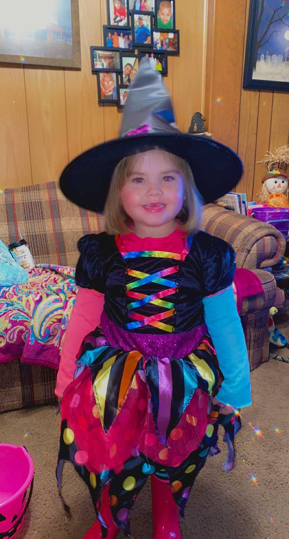 Blakely is registered to the contest to win money with this photo: baby_toddler_clothing, chair, child, costume_hat, dress, event, fashion_accessory, fun, happy, hat, headwear, joy, magenta, party_supply, person, pink, purple, room, smile, sun_hat