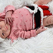 Elizabeth is registered to the contest to win money with this photo: baby, infant, christmas, holiday, red_hat, knitwear, blanket, white_fur, cute, festive, sleepwear, newborn, child, lying_down, cozy, cute_expression, hand, foot, portrait, indoors