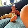baby, child, couch, sofa, relaxed, indoor, window, potted_plant, foot, skin, clothing, pants, long_sleeve, expression, curious, texture, cozy, home, pregnant_belly, casual