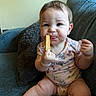 baby, child, snack, couch, blue_couch, crumbs, face, hair, sitting, eating, hand, mouth, curious, clothing, onesie, indoor, furniture, cute, portrait, person