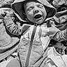 newborn, baby, infant, child, portrait, sleeping, yawning, hood, hooded_outfit, onesie, zipper, blanket, bed, cozy, black_and_white, monochrome, lying_down, arms_raised, face, indoors