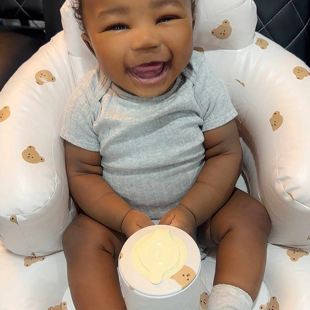 Rimiri joined the competition — help win amazing prizes! baby, bear_pattern, chair, child, container, cushion, cute, furniture, gray_shirt, happy, holding, indoor, infant, inflatable_chair, portrait, sitting, skin, smiling, socks, young_child