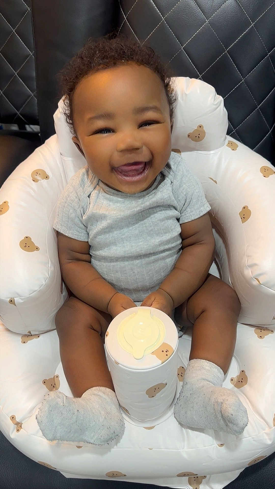 Rimiri joined the competition — help win amazing prizes! baby, smiling, infant, child, sitting, chair, inflatable_chair, bear_pattern, container, holding, socks, gray_shirt, cute, happy, indoor, furniture, cushion, young_child, portrait, skin