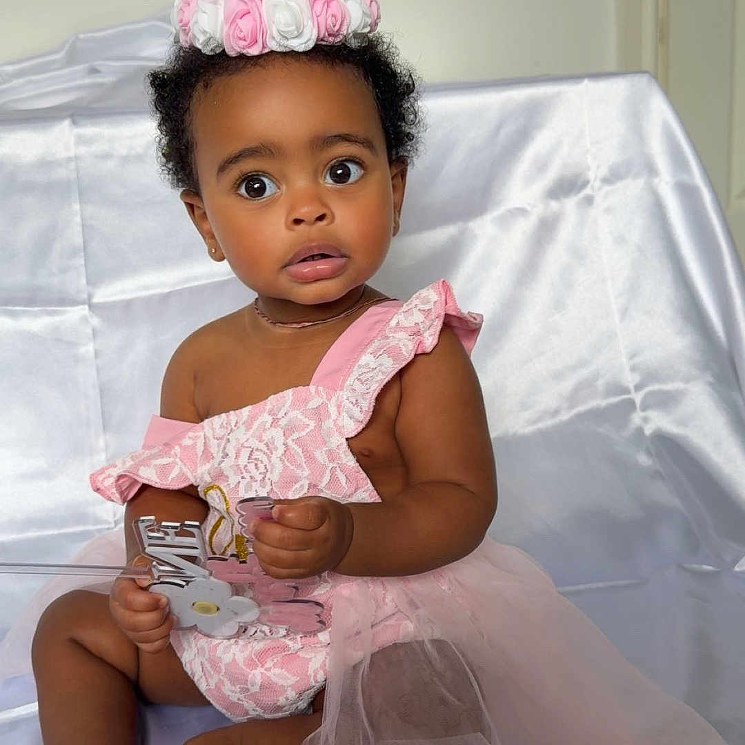 Melona joined the competition — help win amazing prizes! accessory, baby, background, birthday_crown, celebration, child, cute, fabric, foot, hand, headwear, indoor, lace, one_year_old, person, pink_dress, portrait, sitting, skin, surprised_expression