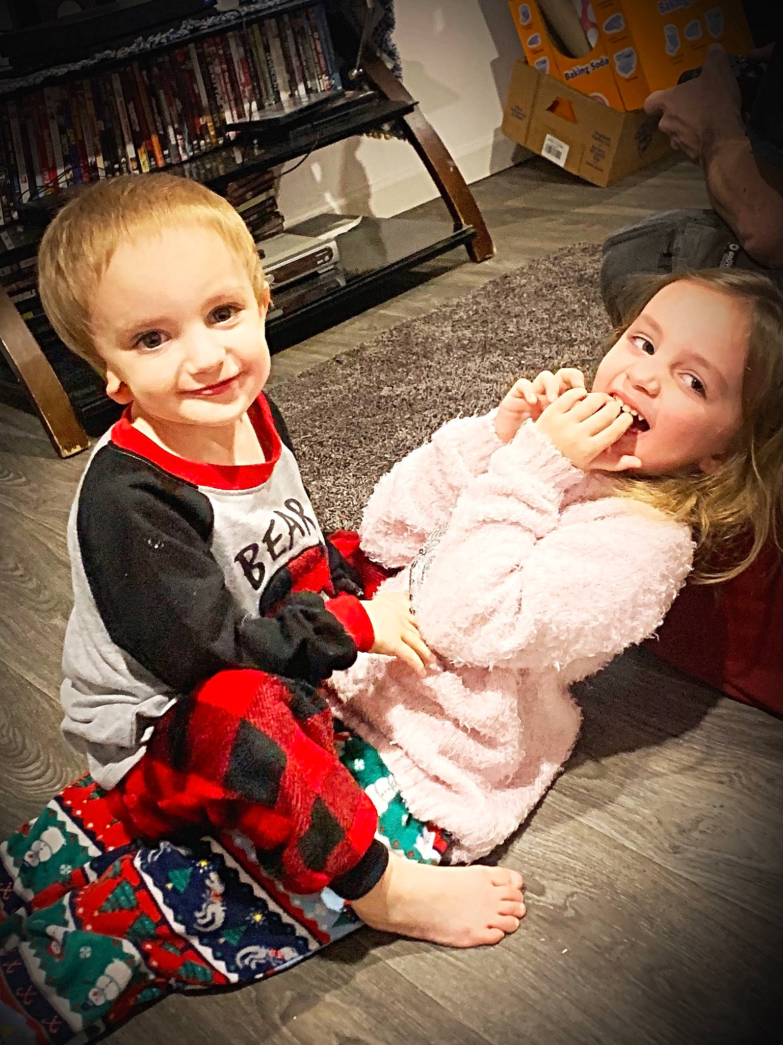 Justin is registered to the contest to win money with this photo: baby, baby_toddler_clothing, bow_tie, child, eye, happy, human_body, joy, lap, laugh, living_room, mouth, overall, person, plaid, playing_with_kids, shelf, shipping_box, sock, tartan