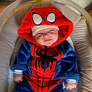Santino a rejoint le concours — aidez-le/la à gagner de superbes lots ! baby, child, infant, costume, spiderman, hood, smile, face, couch, furniture, indoor, cute, plush, clothing, person, seat, baby_rocker, happy, headwear, cute_face