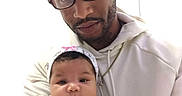 Mich'A is registered to the contest to win money with this photo: baby, infant, child, father, parent, portrait, selfie, 抱抱, cuddling, family, smiling, glasses, cap, hoodie, white_clothing, headband, onesie, indoor, close_up, photograph