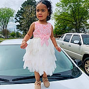Aaliyah is registered to the contest to win money with this photo: blackhair, car, child, clothing, dress, eveningdress, face, female, formalwear, girl, head, person, photography, portrait, sitting, skirt, sleeve, standing, transportation, vehicle