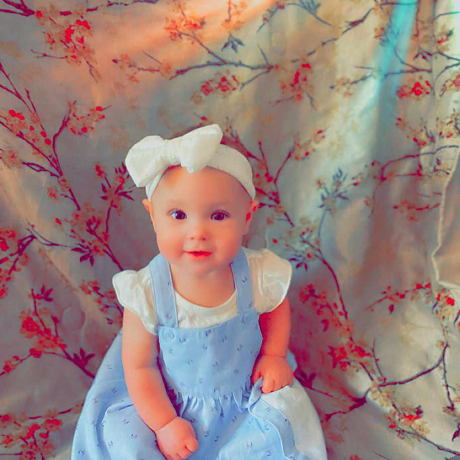 Raya Mea is registered to the contest to win money with this photo: accessories, baby, bonnet, clothing, costume, dress, face, fashion, flower, formalwear, gown, hat, head, newborn, person, photography, plant, portrait, sitting, toy