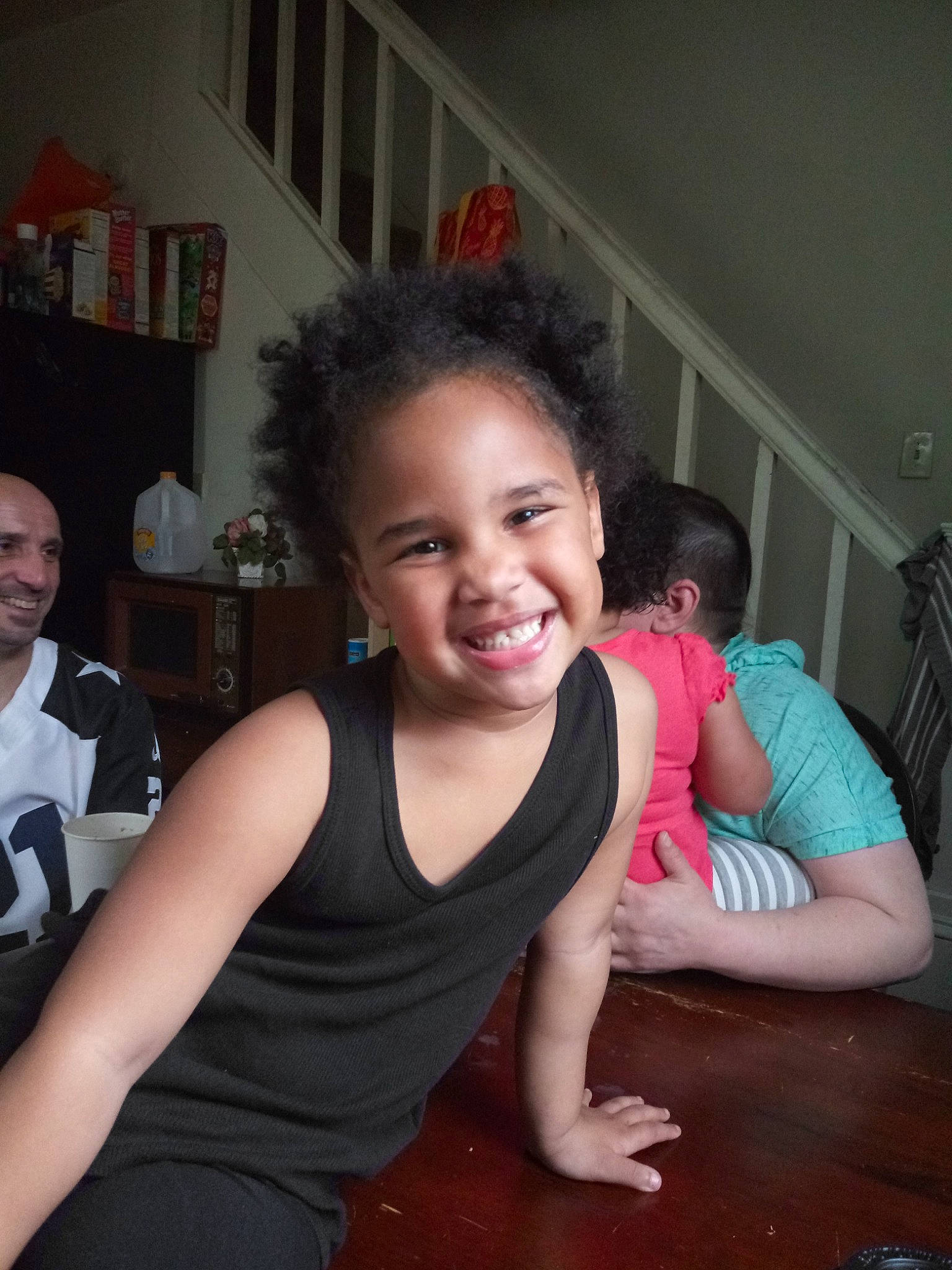 Lily is registered to the contest to win money with this photo: arm, black_hair, cheek, child, fun, happy, joy, leg, person, shoulder, sitting, smile, thigh, toddler