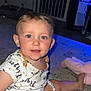 baby, baby_gate, blue_eyes, bracelet, carpet, casual, child, cute, floor, home, indoor, infant, light, onesie, pacifier, person, playful, smiling, toddler, toy