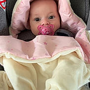 Ellie participe au concours pour gagner de l'argent avec cette photo : baby, pacifier, blanket, car_seat, pink, cream, star_pattern, child, infant, cute, face, hood, warm, cozy, comfort, clothing, seat, head_support, indoor, portrait