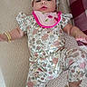 baby, child, infant, pajamas, floral_pattern, headband, bracelet, bib, bed, blanket, pattern, pink, ladybug, flower, sleepwear, cute, lying_down, indoors, person, toddler