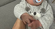 Rafael a rejoint le concours — aidez-le/la à gagner de superbes lots ! baby, infant, sleeping, pacifier, onesie, bear_design, hand, couch, adult, cozy, soft_fabric, indoor, relaxation, calm, child, person, home, rest, cute, comfort