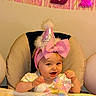 Kensli is registered to the contest to win money with this photo: baby, child, party_hat, pink_bow, high_chair, balloons, celebration, smiling, indoor, birthday, festive, decorations, person, cute, infant, headwear, happy, pink, white, toddler