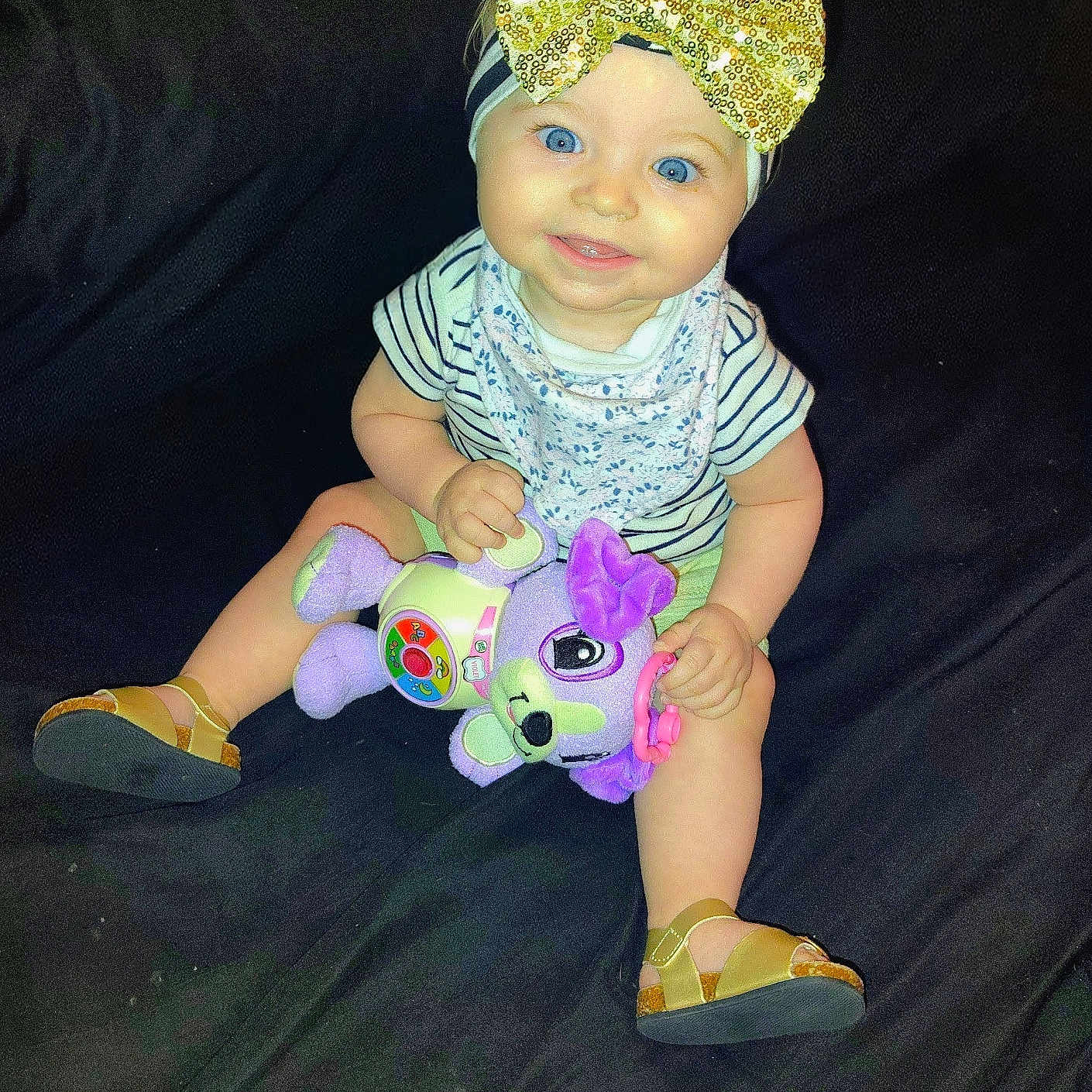 Kensli joined the competition — help win amazing prizes! baby, child, blue_eyes, golden_bow, striped_shirt, plush_toy, purple_toy, sitting, smiling, golden_sandals, headband, indoor, cute, portrait, happy, person, infant, toy, clothing, face