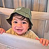 Matteo participe au concours pour gagner de l'argent avec cette photo : baby, background, child, clothing, curtains, cute, face, green_hat, hands, happy, hat, indoors, looking_at_camera, mesh, person, playpen, portrait, smiling, toddler, young_child