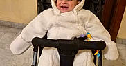 Matteo a rejoint le concours — aidez-le/la à gagner de superbes lots ! baby, child, clothing, cozy, cute, door, ears, happy, hood, indoor, infant, marble_floor, person, seat, smiling, stroller, toy, warm_clothing, white_bear_suit, wooden_door