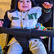 Matteo participe au concours pour gagner de l'argent avec cette photo : baby, casual, child, clothing, face, hand, happy, headwear, jacket, night, outerwear, person, seat, smiling, stroller, toddler, toy, urban, waving, winter_hat