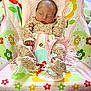 newborn, baby, sleeping, onesie, floral_pattern, blanket, baby_rocker, fisher_price, colorful, flower_pattern, infant, cozy, indoors, child, soft, cute, peaceful, resting, baby_clothing, toddler