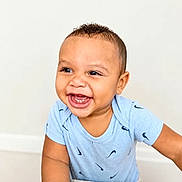Richard joined the competition — help win amazing prizes! baby, toddler, child, smiling, happy, face, person, blue_shirt, short_sleeve, indoor, cute, joyful, small_child, leaning, light_background, portrait, expressive, curly_hair, skin, photography