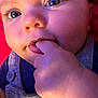apparel, baby, blue_eyes, button, child, close_up, clothing, cute, expression, face, fingers, hand, infant, person, pink_background, portrait, skin, soft_lighting, sucking, young