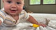 Bodie joined the competition — help win amazing prizes! baby, blanket, child, curtains, cute, face, floor, hand, happy, home, indoor, infant, light, lying_down, pacifier, person, smiling, striped_clothing, toy, window