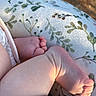 Bodie is registered to the contest to win money with this photo: baby, legs, feet, skin, toes, infant, close_up, cushion, floral_pattern, soft_light, natural_light, child, resting, cute, chubby, pale_skin, texture, indoors, comfort, warmth