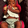 baby, child, car_seat, headband, cloth, infant, warning_label, padded_background, red_car_seat, curious, cute, sitting, indoors, portrait, hands, expression, clothing, skin, young_child, closeup