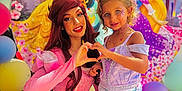 Aria a rejoint le concours — aidez-le/la à gagner de superbes lots ! child, princess, costume, face_paint, tiara, balloons, disney_princesses, heart_shape, smile, dress, purple_top, mermaid_skirt, pink_gown, woman, celebration, party, happy, outdoor, portrait, colorful