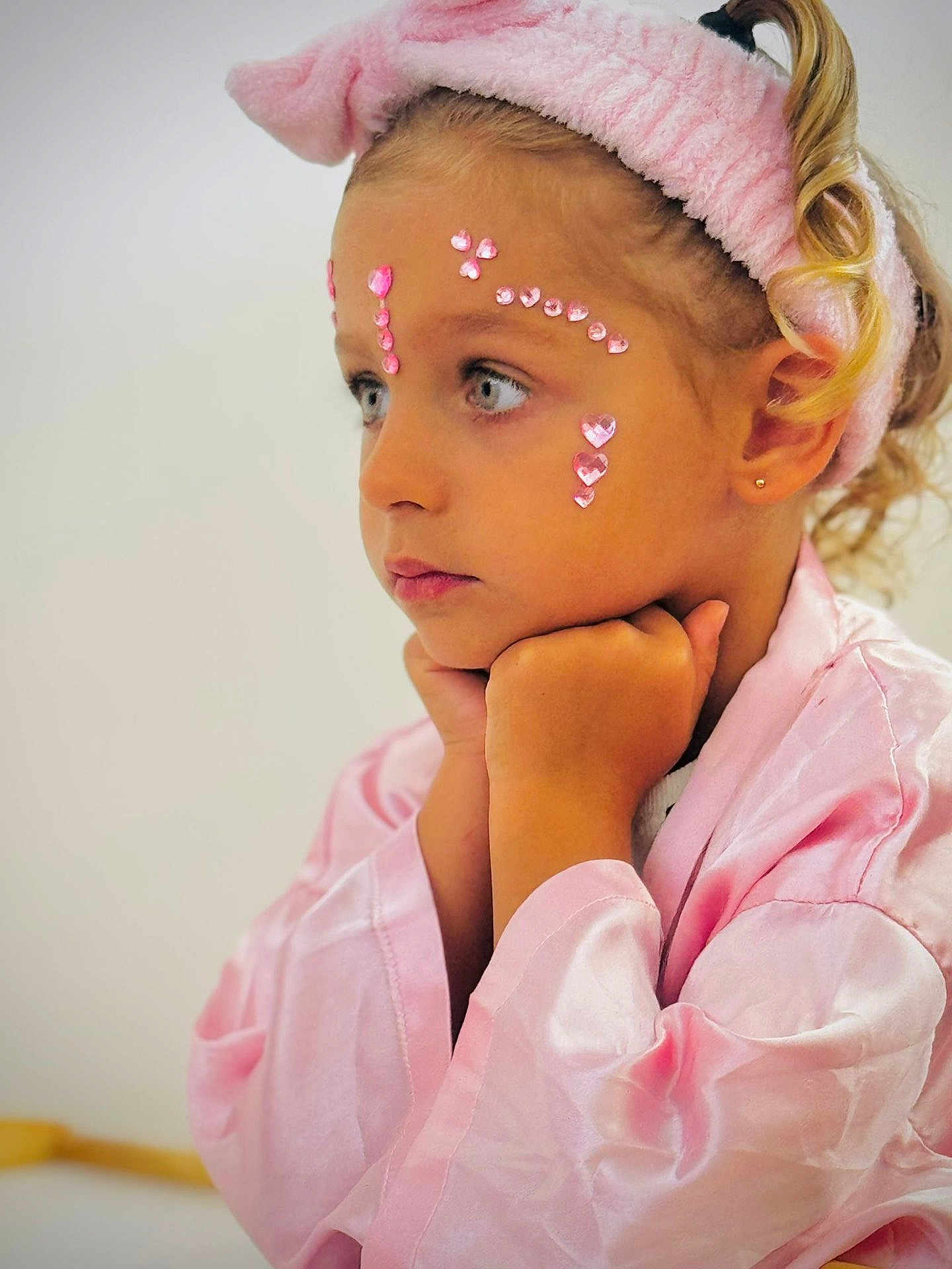Aria participe au concours pour gagner de l'argent avec cette photo : child, girl, pink, robe, headband, face_gems, curly_hair, portrait, side_view, thoughtful, resting_chin, young_child, indoor, soft_lighting, skin, earring, expression, closeup, cute, fashion
