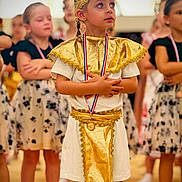 Aria a rejoint le concours — aidez-le/la à gagner de superbes lots ! child, children, costume, gold, medal, performance, ceremony, group, indoor, dress, standing, proud, young, event, people, focused, decorative, celebration, team, posing