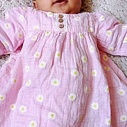 Ina participe au concours pour gagner de l'argent avec cette photo : baby, blanket, buttoned_dress, child, comfortable, cozy, cute, daisies, face, happy, indoors, infant, lying_down, pink_dress, portrait, sleepwear, smiling, soft_texture, warm, young_child