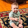 baby, barefoot, carpet, child, chubby, couch, cute, face, hands, hardwood_floor, home_interior, infant, legs, living_room, onesie, portrait, rug, sitting, smile, toe