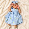 baby, infant, child, portrait, lying_down, blanket, blue_dress, striped_clothing, bow, headband, sandals, fashion, indoors, soft_blanket, smiling, face, hands, feet, baby_photography, cute