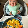 Michael joined the competition — help win amazing prizes! baby, high_chair, food, breakfast, toast, peanut_butter, eggs, mandarin, fruit, plate, person, smile, child, feeding, bib, blue_bib, indoor, carpet, hand, happy