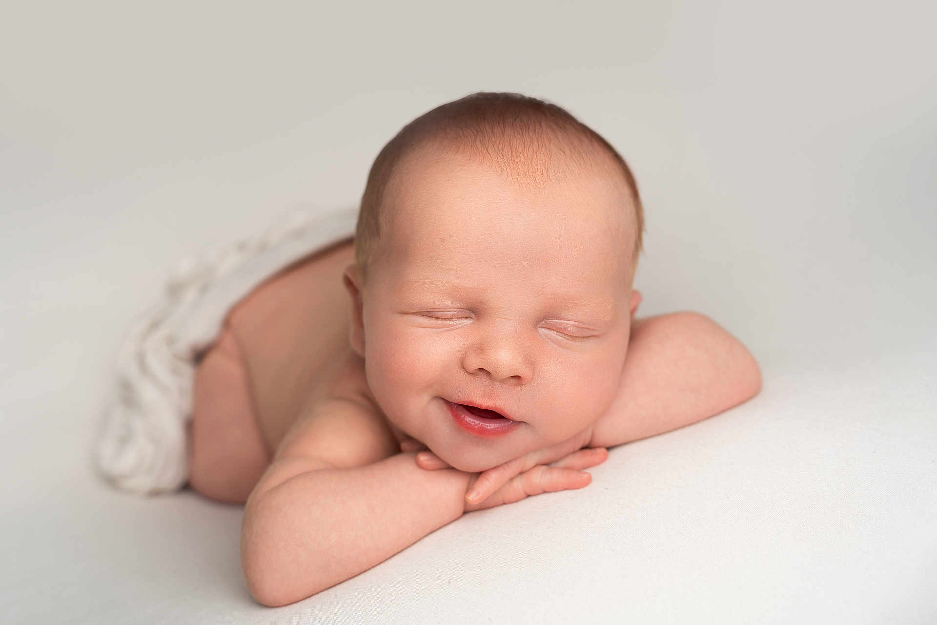 Vinnie is registered to the contest to win money with this photo: newborn, baby, sleeping, smiling, infant, resting, arms, face, skin, head, peaceful, white_background, blanket, soft, portrait, cute, closeup, child, tiny, wrapped