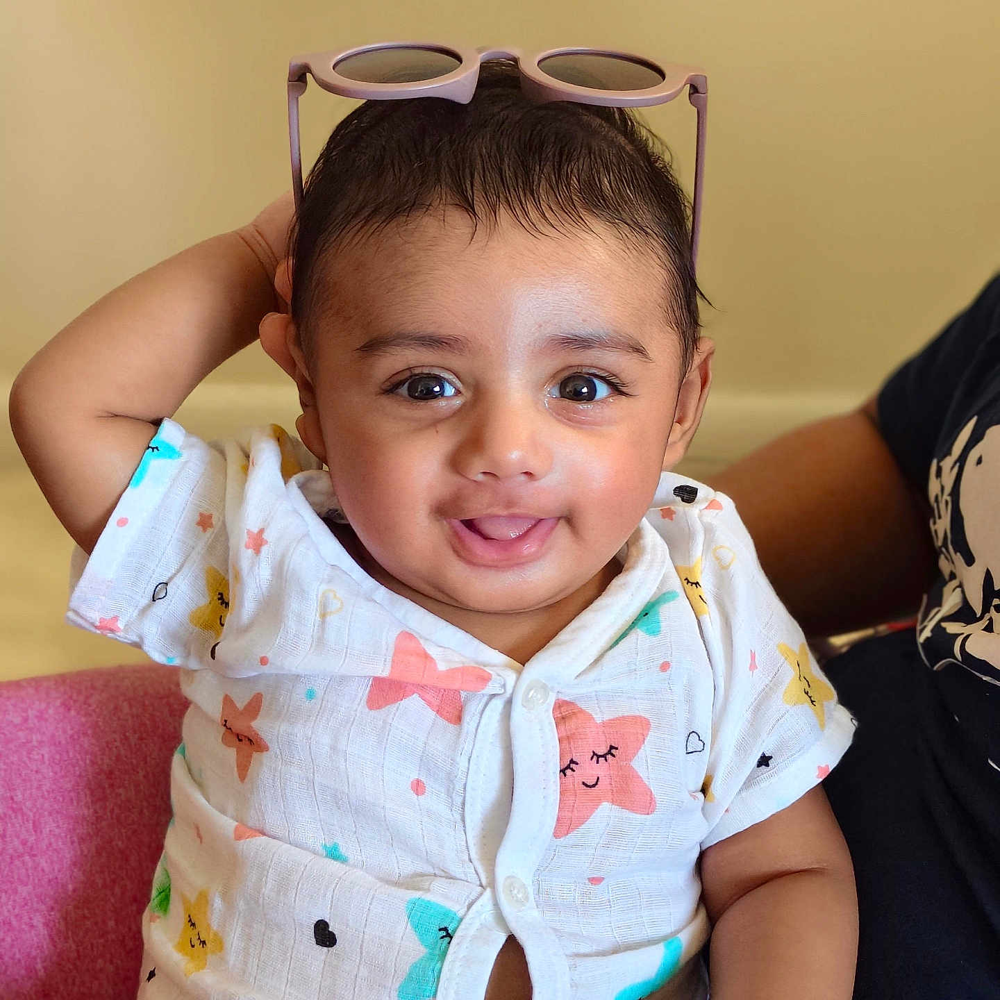 Riaan joined the competition — help win amazing prizes! baby, child, smiling, sitting, indoor, clothing, pink_chair, sunglasses, star_pattern, cute, portrait, happy, person, infant, short_hair, casual, playful, expression, light_background, hand_up