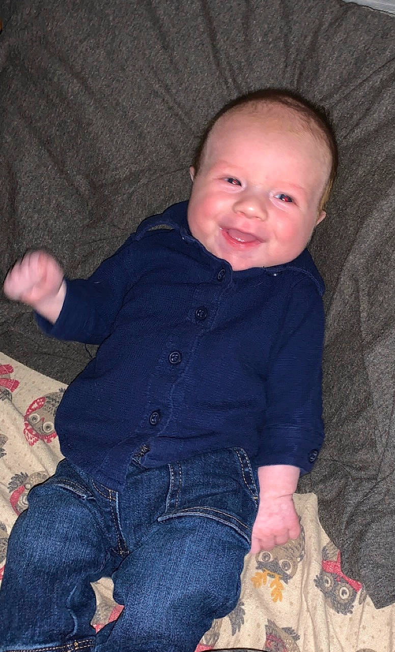 Parker is registered to the contest to win money with this photo: baby, baby_toddler_clothing, cheek, child, chin, comfort, eye, face, finger, head, iris, joy, lap, nose, pattern, person, sitting, skin, sleeve, smile