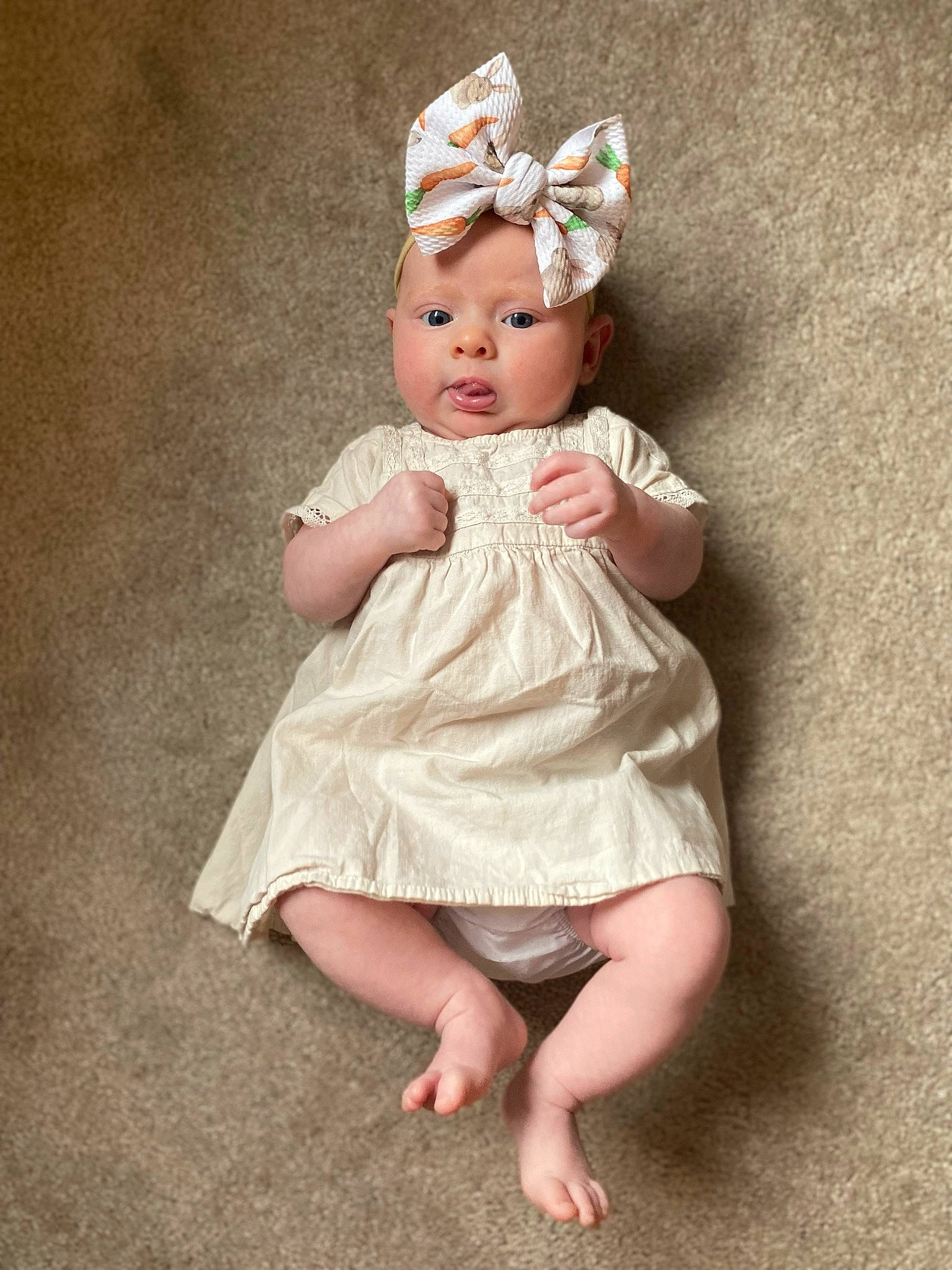 Saige is registered to the contest to win money with this photo: baby, baby_toddler_clothing, child, day_dress, dress, embellishment, fashion_accessory, finger, grass, hair_accessory, hand, headband, headgear, headpiece, headwear, iris, pattern, person, sitting, sleeve