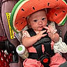 Victoria joined the competition — help win amazing prizes! baby, infant, car_seat, watermelon_hat, hat, baby_bottle, hand, clothing, pink_outfit, seatbelt, child, cute, face, eyes, fingers, sitting, comfort, indoor, person, closeup