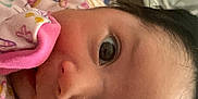Nayeli is registered to the contest to win money with this photo: baby, infant, face, closeup, blanket, floral_pattern, curious, indoors, cozy, child, person, young, sleepwear, head, skin, eyelashes, soft, cute, comfort, resting