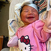 Nayeli joined the competition — help win amazing prizes! baby, newborn, smiling, pink_clothing, headband, hello_kitty, blanket, infant, cute, sleepwear, portrait, child, soft_toys, indoor, happy, lying_down, small_hands, cozy, face, person