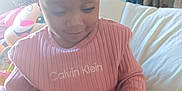 Khaycee joined the competition — help win amazing prizes! toddler, child, pink_clothing, headband, smiling, indoor, couch, toy, television, curly_hair, person, cozy, home, furniture, casual, sitting, young_child, happy, playful, relaxed