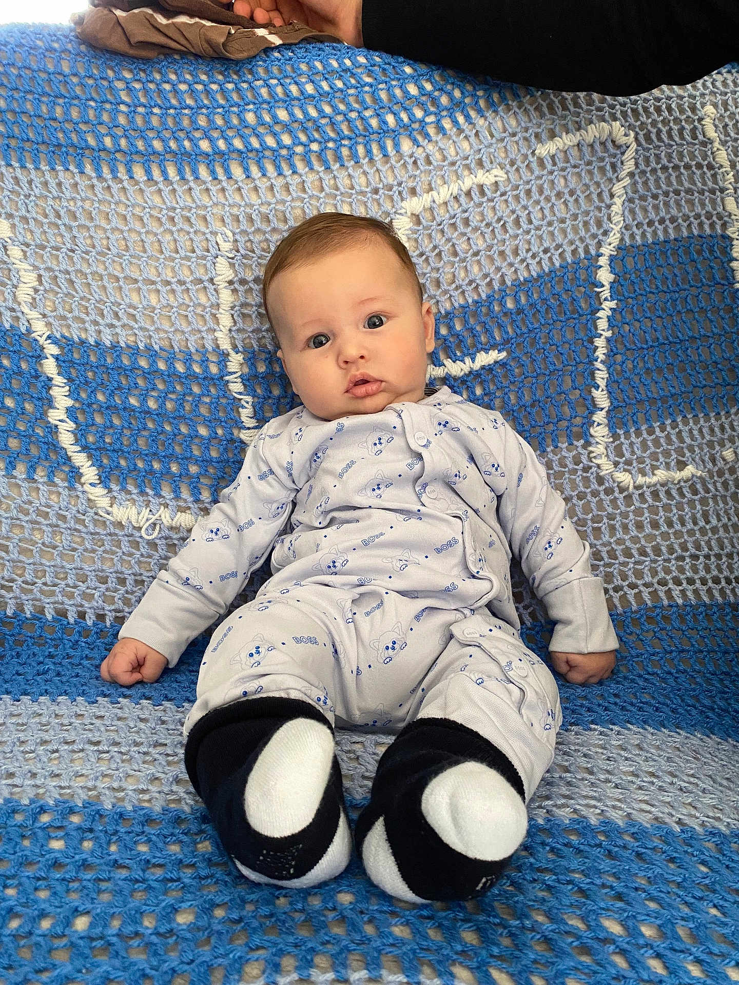 Tiziano participe au concours pour gagner de l'argent avec cette photo : baby, infant, pajamas, blue, white, crocheted_blanket, hand, sitting, cozy, cute, face, person, child, footwear, socks, indoors, portrait, soft_texture, looking_at_camera, comfort