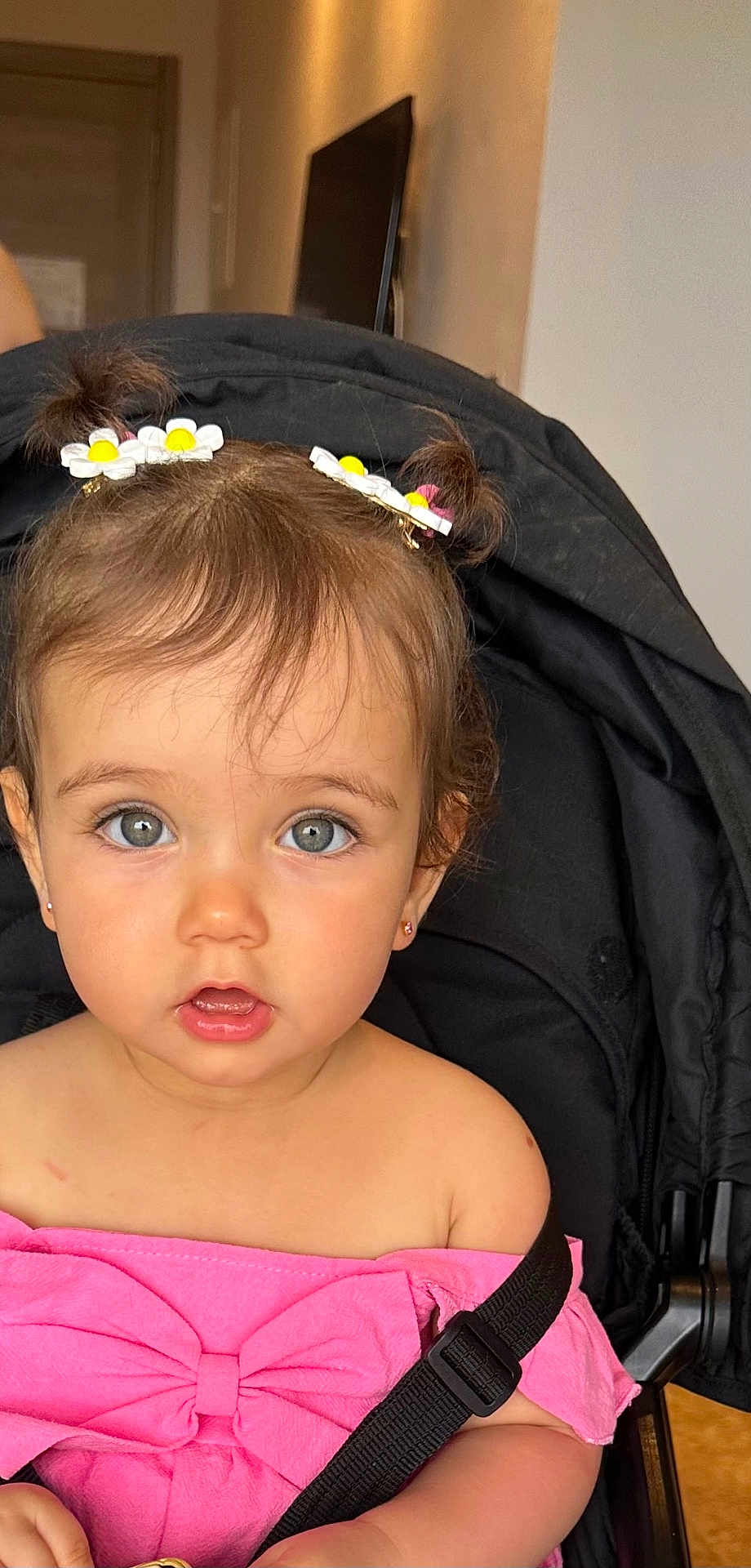 Layane participe au concours pour gagner de l'argent avec cette photo : toddler, child, baby, girl, pigtails, hair_clips, daisy, pink_clothing, bow, stroller, black_strap, indoor, curious_expression, blue_eyes, cute, portrait, seatbelt, face, skin, small_earrings