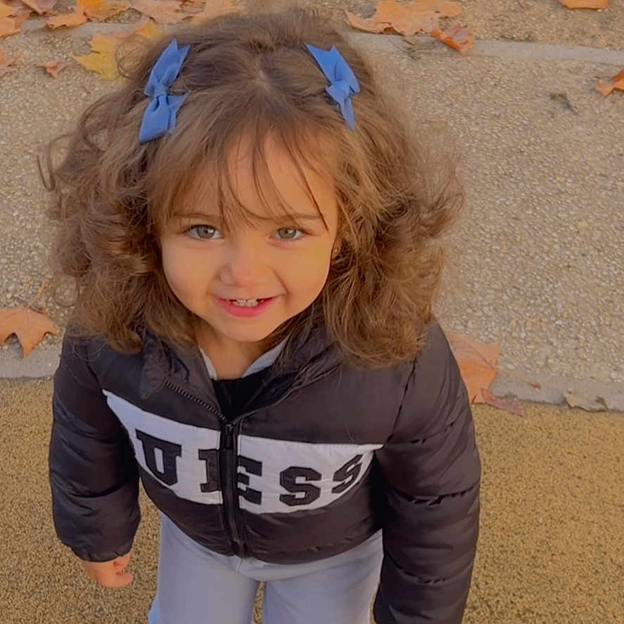 Layene a rejoint le concours — aidez-le/la à gagner de superbes lots ! autumn, blue_bows, casual, child, curly_hair, cute, fashion, girl, ground, happy, jacket, leaves, outdoor, person, playful, portrait, smiling, standing, white_shoes, young